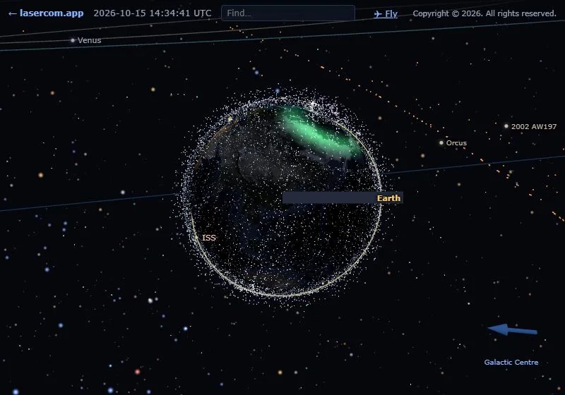 Earth with a bright green auroral glow over the northern polar region, inside the shell of satellites.